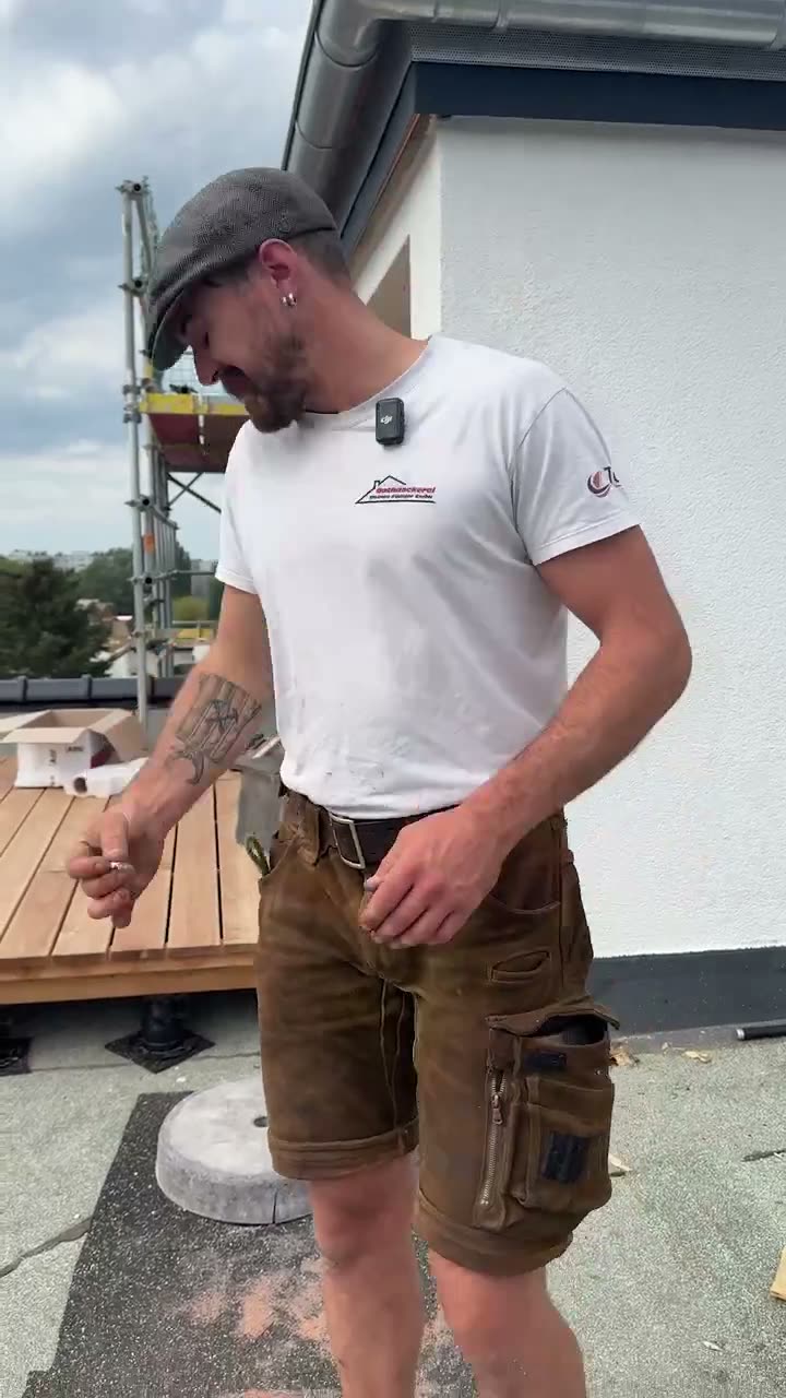 Arbeitsszene auf einer Dachbaustelle mit Kran im Hintergrund