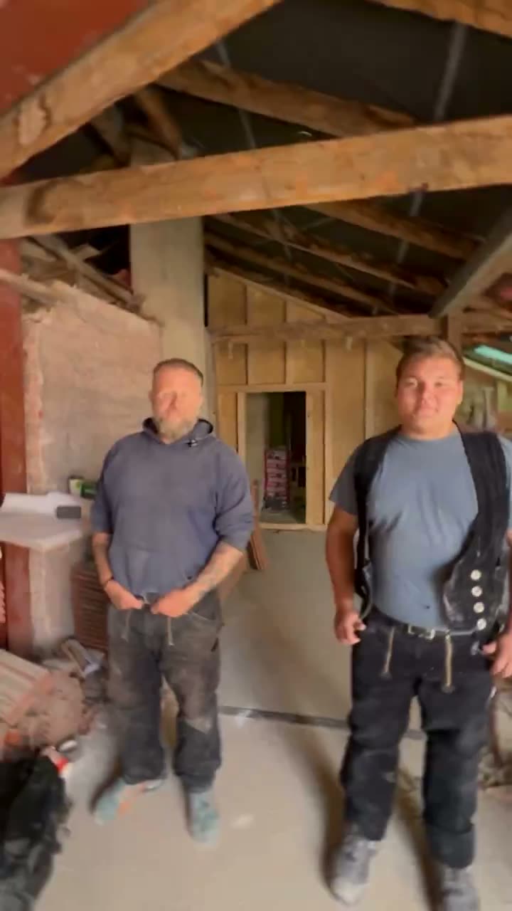 Zwei Handwerker im offenen Dachstuhl, aufgenommen bei vorhandenem Licht